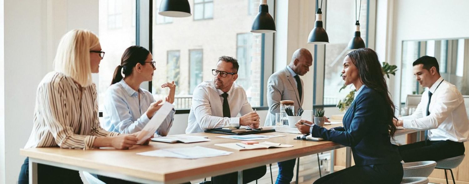 Family business owners in a UAE boardroom discussing compliance documents